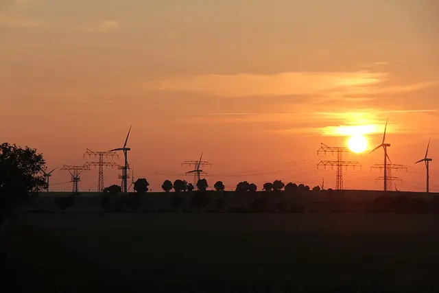 Wind turbines and power lines at sunset